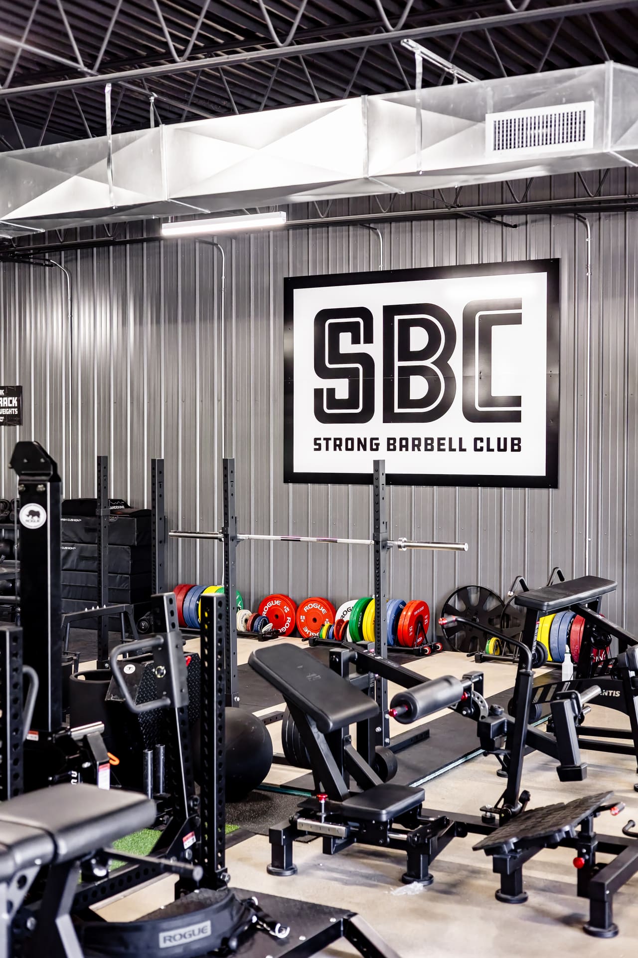 Squat rack and racks of plates at Strong Barbell Club Manhattan